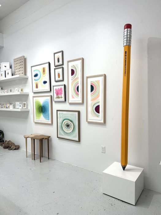 Colorful abstract art gallery with a giant pencil sculpture focusing on life demands on both ends.